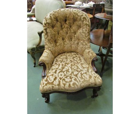 A circa 1860 walnut button back armchair, the scroll outswept arms over a serpentine front seat, with floral carved scroll le