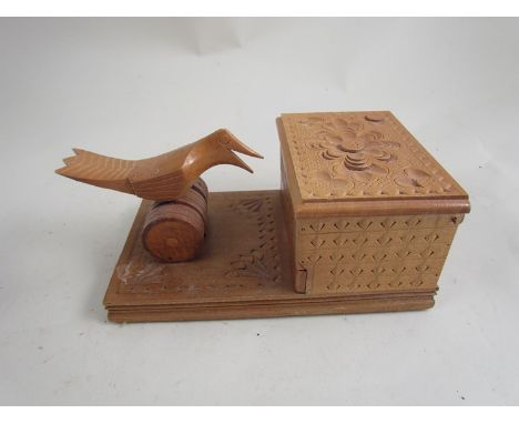 A carved wooden cigarette box with push button bird mechanism 