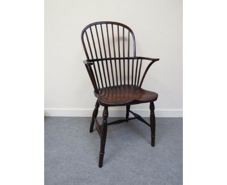 A circa 1840 stick back Windsor armchair, the dished elm seat over turned legs joined by and "H" stretcher 