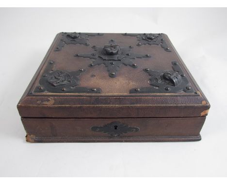 A 19th Century cribbage set the brown leather box with Egyptian mask mounts, the compartmental interior with gilt cribbage bo