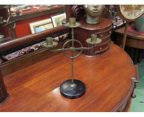 A brass three sconce candlestick on wooden base