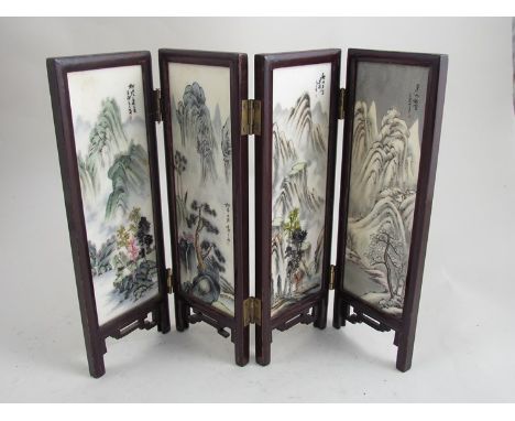 An Oriental four fold table screen with eight hand painted ceramic panels