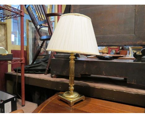 A brass table lamp with cream pleated shade and fluted column 