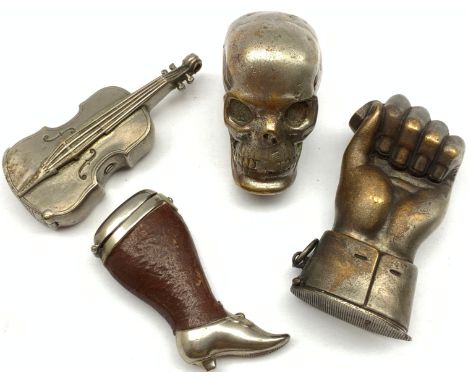 Four novelty vesta cases comprising plated skull, plated cello, leather and plated case in the form of a lady's leg marked De