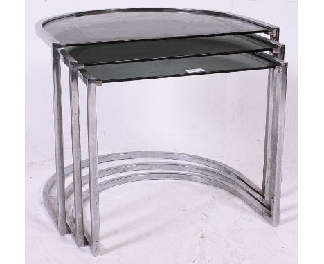 A 1970's half moon shaped chrome and smoked glass retro nest of tables together with 3 vintage plastic chairs, 2 of which are