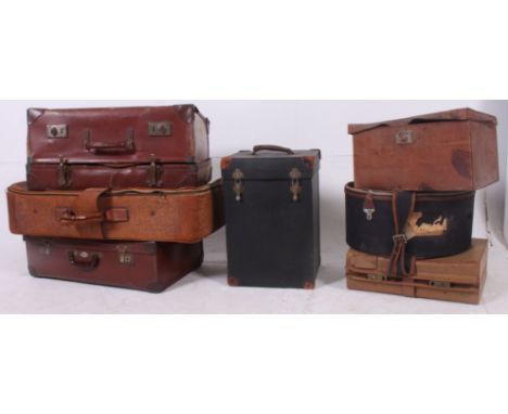 A stack of vintage suitcases to include leather, vinyl, canvas etc dating from the early to mid 20th century