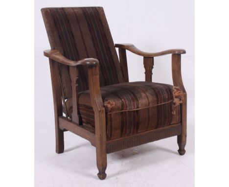 A 1940's vintage oak reclining fireside chair raised on squared legs with original upholstery. H74 x W60 x D46cm