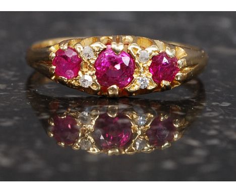 A late Victorian 18ct gold ruby and diamond ring. The round cut central ruby approx 20pnts with a further 2 x 10pnt ruby ston