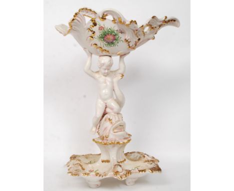 An early 20th century Italian Bassano stamped faience large ceramic figure of a cherub holding atop a large shell, with hand 