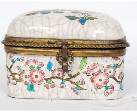 A Longwy style brass mounted and ceramic ladies jewellery casket with upholstered inside lid. Decorated with birds of paradis