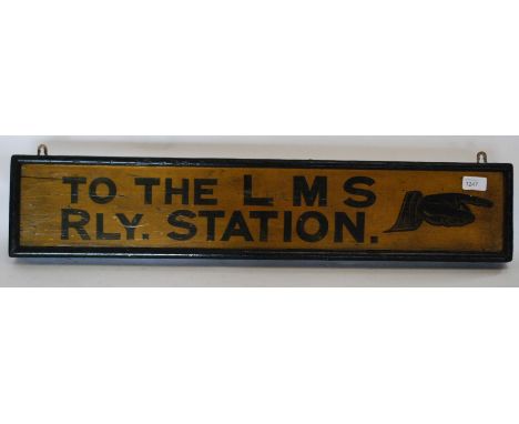 A vintage wooden painted railway sign with notation for LMS - Railway Station set in black font on yellow ground