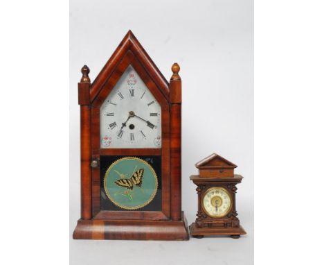 A 19th century walnut cased American gingerbread clock with glass facia and butterfly painted glass. The movement set behind 