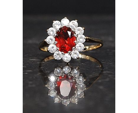 A 9ct hallmarked gold ring set with CZ and a central red gemstone. Weight 2.3g. Size Q

