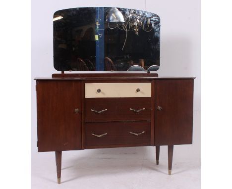 A vintage 1960's two tone dressing table chest of drawers. Raised on tapered turned legs with a series of drawers and cupboar