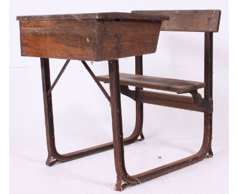 A vintage early 20th century cast iron and oak school desk. The iron frame with applied seat and hinged top desk. H77 x W62 x