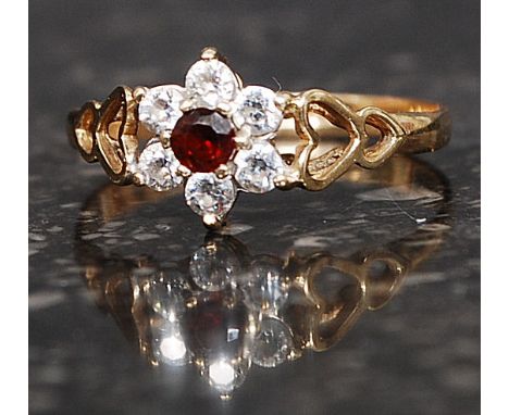 A 9ct gold hallmarked cluster ring set with CZ and central garnet within heart shaped shoulders. Weight 1.4. Size O.
