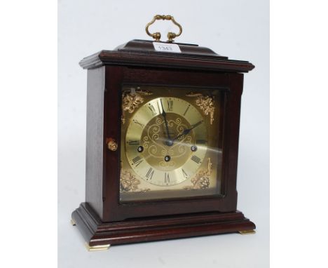 A 20th century mantel clock in mahogany with brass features and brass handle to top. The dial stamped Metamec, with brass mov