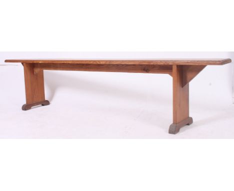 A 19th century French provincial pine refectory pig bench having a planked top with angled supports to the underside. Near Ma
