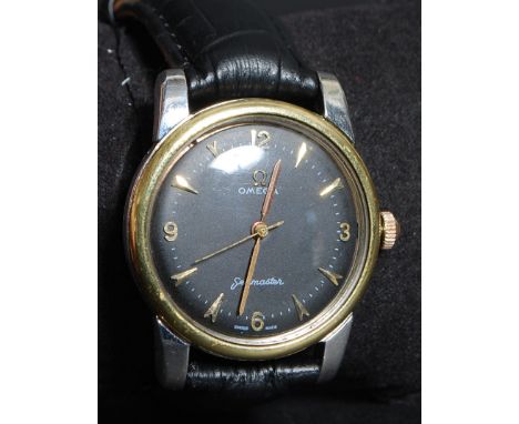 A gentlemans vintage 1950's Omega Seamaster wristwatch. The black faced dial with gilt baton numerals and hourly markers with