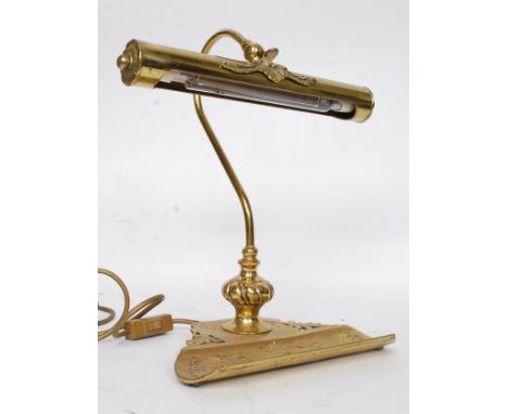 A 20th century vintage style brass desk lamp having a pen tray attached to the base