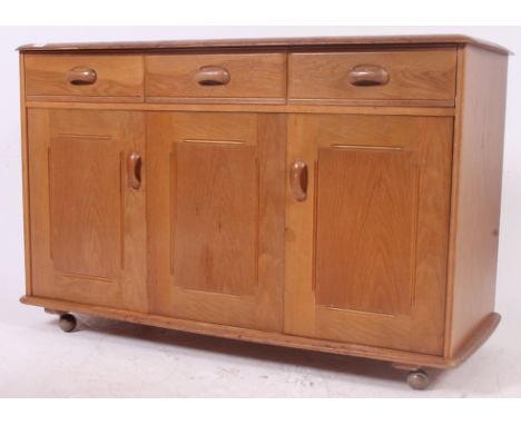 A vintage 1970's retro pale oak sideboard in the Ercol style, likely by Priory. The chamfered top over bi-fold doors raised o