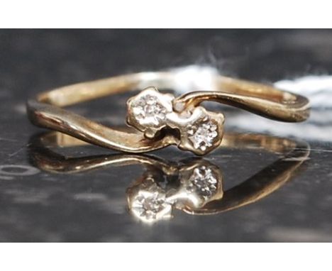 An 18ct gold ladies diamond ring. The diamonds being claw mounted with swirl suspension on plain shank. Ring size O