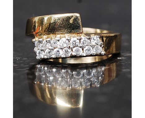 A 9ct gold hallmarked dress ring set with clear stones in an overlapping twin band. Weight 3.3g. Size K.
