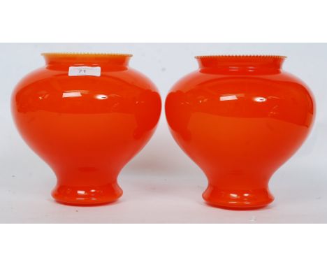 A pair of retro orange glass light / lamp shades, having a bulbous body. H22 cm 