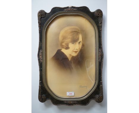 A 1920s tinted photographic portrait of a young woman, in a parcel-gilt frame, 44 x 26 cm