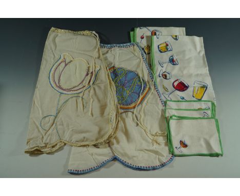 Two 1930's hand-made aprons with tulip patch pockets trimmed with crewel work embroidery, and a set of 1950's kitsch printed-