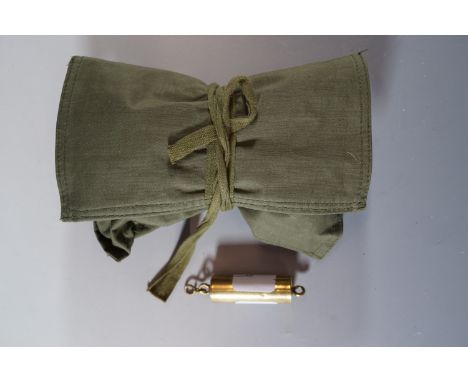 A British army tropical sewing kit and brass rifle barrel bore viewing tool.