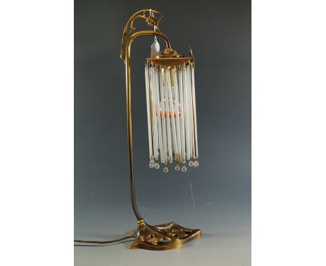 A contemporary brass table lamp with glass drops