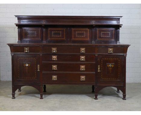 An Art Nouveau mahogany sideboard, c.1900, the panelled superstructure with a shelf, above three frieze drawers, over a pair 