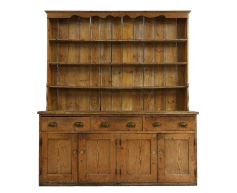 A large pine dresser,  early 19th century, the boarded back with three shelves, over three drawers and two pairs of cupboards