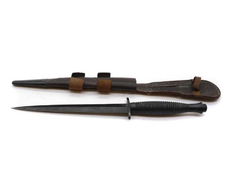 A Fairbairn-Sykes Fighting Knife Mid 20th century, Type III, with blackened finish, ribbed grip and in a leather scabbard30cm