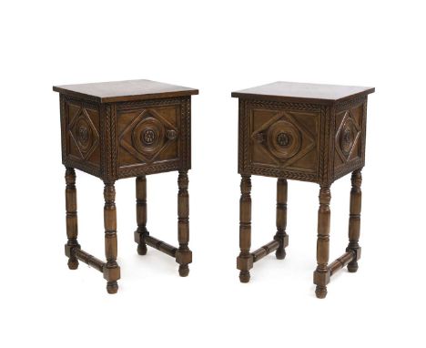 A pair of carved walnut bedside tables,  early 20th century, in the Elizabethan style, with single cupboard doors, raised on 