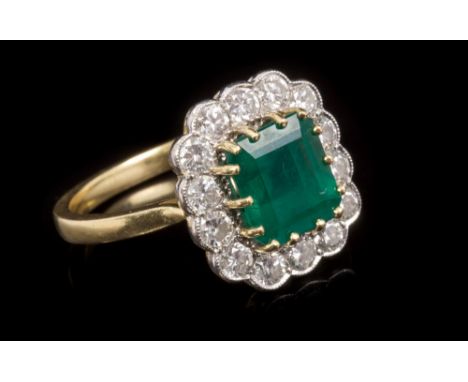 Ladies' emerald and diamond cluster ring with a rectangular step cut emerald estimated to weigh approximately 2 carats, surro