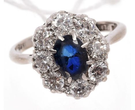 Sapphire and diamond cluster ring, the oval cluster centred with an oval mixed cut blue sapphire surrounded by a border of ei