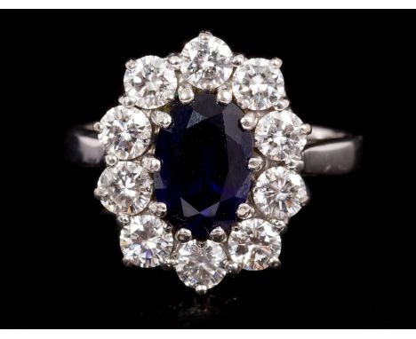 Sapphire and diamond cluster ring, the oval cluster centred with an oval mixed cut blue sapphire estimated to weigh approxima