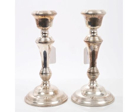 Pair contemporary silver candlesticks of tapering form, with reeded decoration and inverted bell candle holders, on circular 