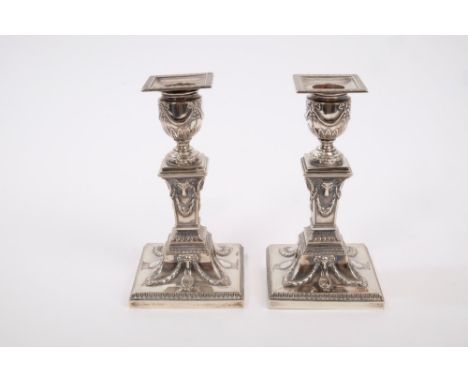 Pair late Victorian silver candlesticks of classical form, with tapering square stems and ram's head and garland decoration, 