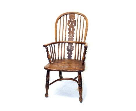 Early 19th century ash and elm windsor elbow chair with arched stick back and pierced splat, with solid saddle seat on turned