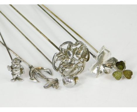 SILVER HAT PINS ETC. A silver floral hat pin, hinged & two other silver hat pins, an ivy leaf & a fouled anchor. Also, three 