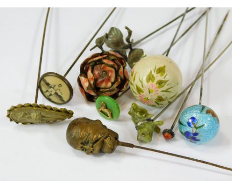MISCELLANEOUS HAT PINS. Hat pins in painted wood, foiled enamel, carved lava etc. Also, a Wembley Exhibition hat pin, a footb