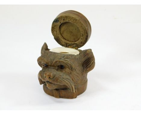 DOG INKWELL. A 19th century Swiss Black Forest carved dog inkwell with ceramic glass liner. Height 7cm.  Please note that all