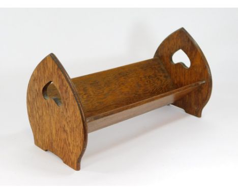 ARTS & CRAFTS BOOK TROUGH. An Arts & Crafts oak book trough with heart shaped pierced handles. L41.5 x H23cm.  Please note th