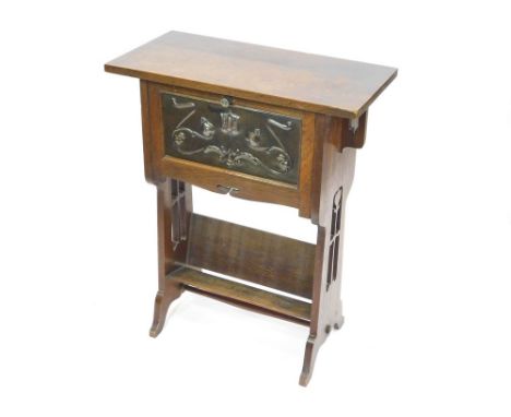 ARTS & CRAFTS SIDE TABLE. An Arts & Crafts small oak side table with a copper panel inset to a fall front door, above a book 