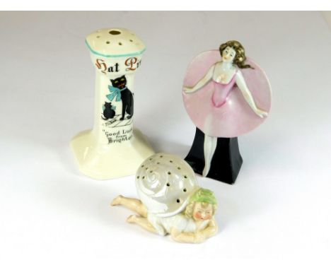 HAT PIN STANDS. An Art Deco standing lady hat pin stand. Height 12cm. Also, a Good Luck from Brighton stand & one other.  Ple