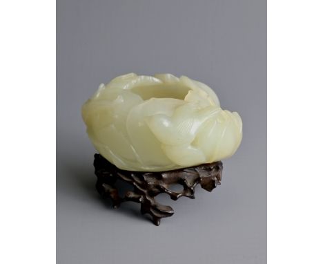 A CHINESE PALE CELADON JADE BRUSH WASHER ON WOODEN STAND, QING DYNASTY. Carved in the form of a lotus blossom with a bird per