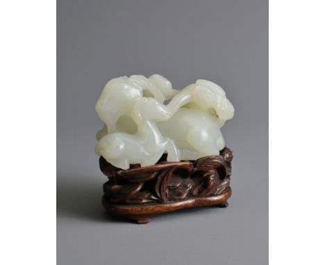 A CHINESE WHITE JADE DEER GROUP ON WOODEN STAND, 19/20TH CENTURY. Carved and pierced in the form of three recumbent deer with